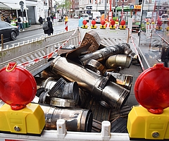 Am Morgen nach dem Brand liegen die Reste des Rauchabzugs auf dem Bürgersteig an der Königstraße. Ein Mitarbeiter des Bauhofs stellte davor Baustellenzäune auf. Die Polizei spannte ein rot-weißes Flatterband auf. Daran hängt der Hinweis, dass das Material beschlagnahmt ist. (Foto: Frank)