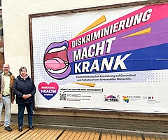 Gleichstellungsbeauftragte Heidi Basting und Bi+Aktivist und Lehrer Frank Thies trafen sich vor dem Plakat, das Teil einer Sichtbarkeitskampagne vom Sozialministerium Schleswig-Holstein ist. (Foto: Frank Thies)