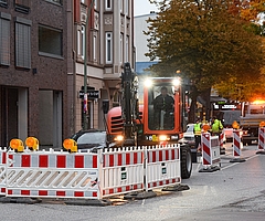 Der Linksabbieger von der Schul- in die Holstenstraße ist gesperrt. Ein Baggerfahrer stemmt den Asphalt auf. (Foto: Frank) 