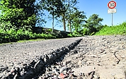 Der Bullendorfer Weg in Elmshorn: Neben der Betonspur klafft eine mehrere Zentimeter tiefe Kante. Es gilt Tempo 30. Das Verkehrsschild weist auf Straßenschäden hin. (Foto: Frank)
