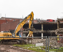 Ein Bagger reißt das Parkhaus am Wedenkamp ab. Kurios: Auf dem oberen Deck steht noch ein roter Transporter. Mindestens eine Fensterscheibe des Wagens ist eingeschlagen. (Foto: Frank)