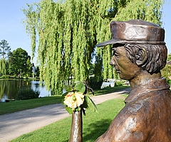 Eine echte Rose ersetzt die Bronze-Blume in der Hand der Gärtner-Skulptur im Rosarium. (Foto: Frank)