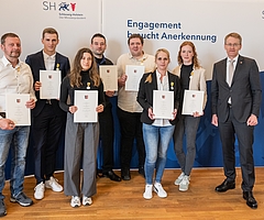 Die Lebensretter von Brokstedt: Heino Wilken (von links), Felix Gerike, Johanna Wassermann, Christopher Strahl, Thomas Brömme, Monika Sibilitz-Prieß, Maria Hitziger und eine Person, die anonym bleiben will. Sie erhielten die Rettungsmedaille am Bande aus den Händen von Ministerpräsident Daniel Günther. (Foto: Frank Peter)